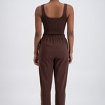 person wearing brown trackpants and a brown top.