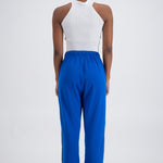 Person wearing blue trackpants on a white background