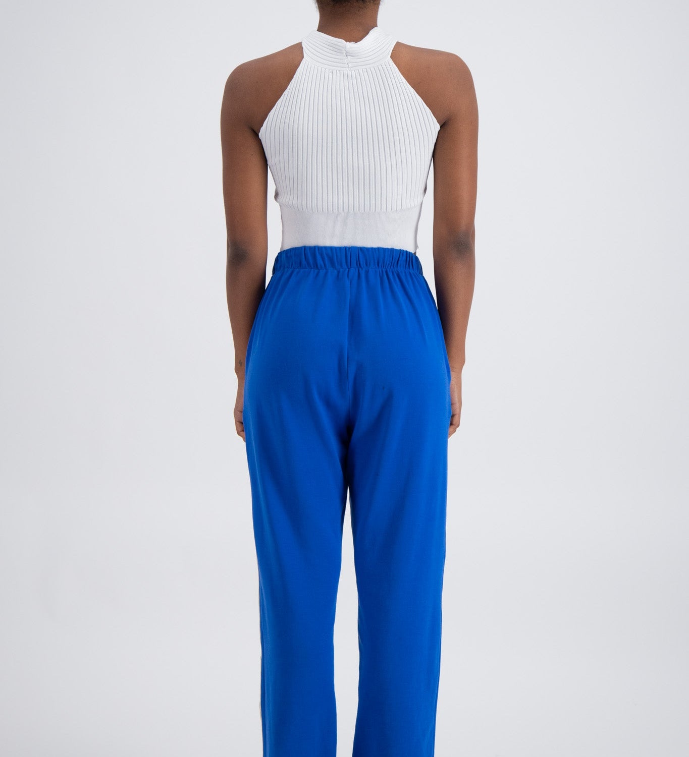 Person wearing blue trackpants on a white background