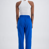 Person wearing blue trackpants on a white background