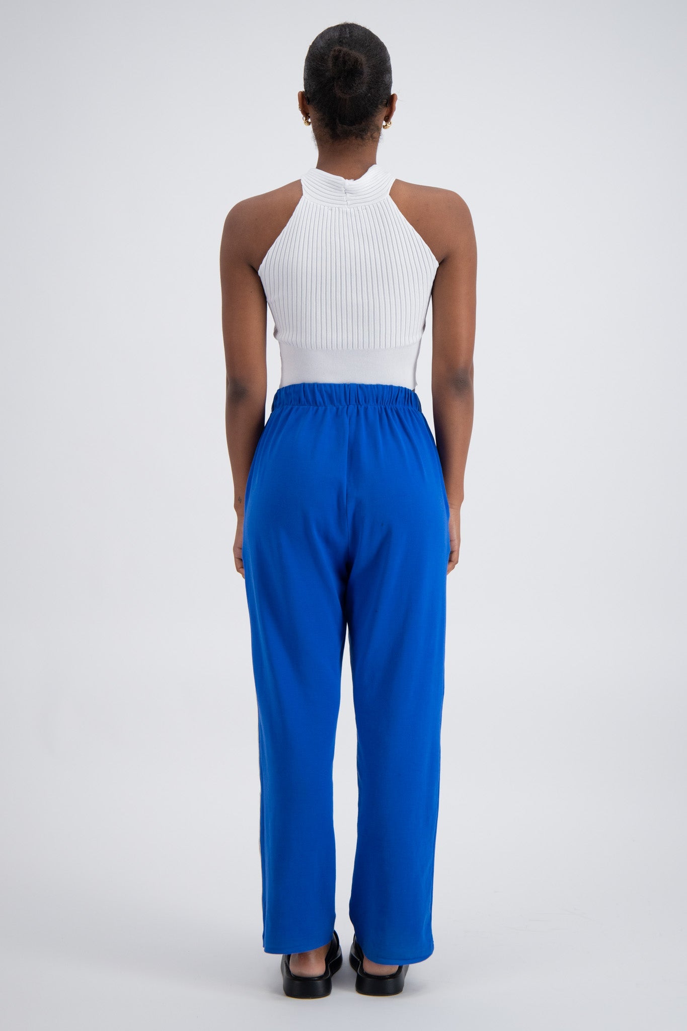Person wearing blue trackpants on a white background