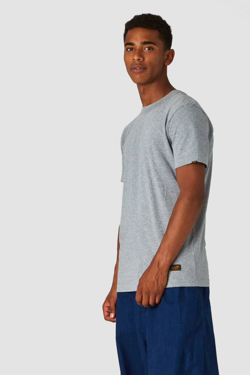 Man wearing a gray t-shirt and blue shorts on a white background