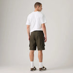 A man shown from the back wearing dark olive green cargo shorts, a white t-shirt, white socks, and brown sneakers, standing against a light gray studio background.