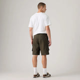 A man shown from the back wearing dark olive green cargo shorts, a white t-shirt, white socks, and brown sneakers, standing against a light gray studio background.