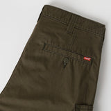 Close-up of dark olive green Levi's pants showing the back pocket with a button and the signature red Levi's tab.