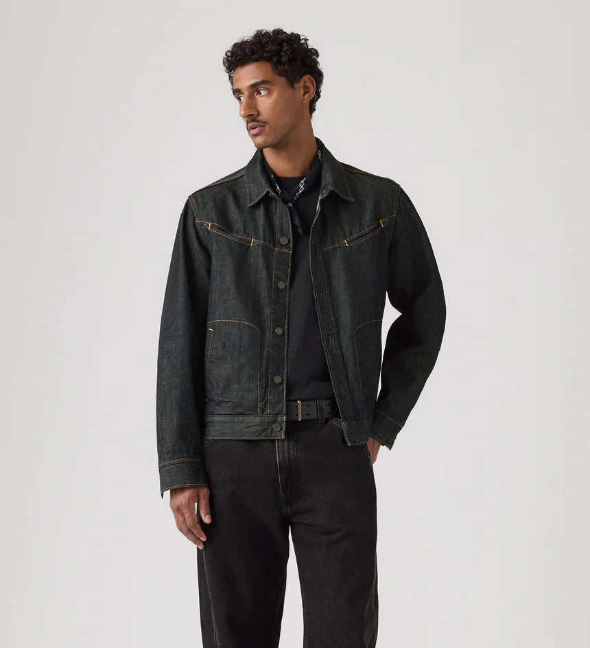 Man wearing a dark denim jacket and jeans on a white background