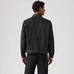 Person wearing a black denim jacket on a white background