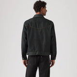 Person wearing a black denim jacket on a white background