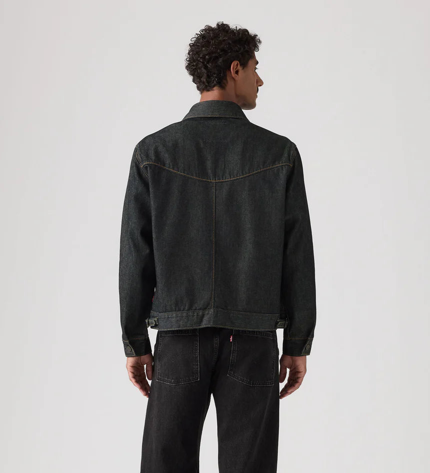 Person wearing a black denim jacket on a white background