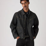 Man wearing a dark denim jacket and jeans on a plain background