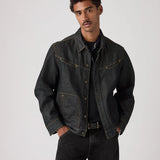 Man wearing a dark denim jacket and jeans on a plain background