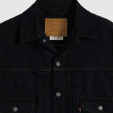 Close-up of a black Levi's denim jacket showing the collar, inner brand patch, snap-button front, and chest pockets on a light gray background.