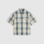 A short-sleeve button-up plaid shirt in beige and teal, displayed flat against a light gray background.