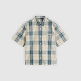 A short-sleeve button-up plaid shirt in beige and teal, displayed flat against a light gray background.