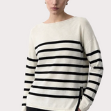 Woman wearing a black and white striped sweater on a plain background