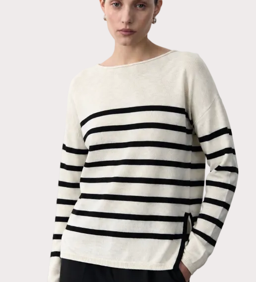 Woman wearing a black and white striped sweater on a plain background