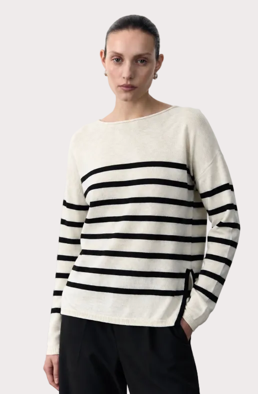 Woman wearing a black and white striped sweater on a plain background