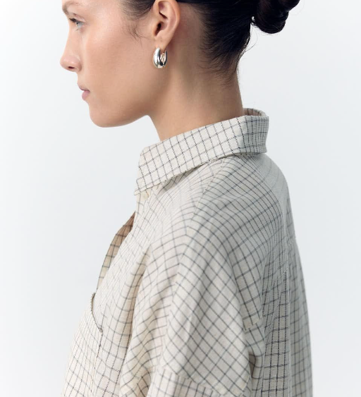 Woman wearing a checkered shirt with a plain background