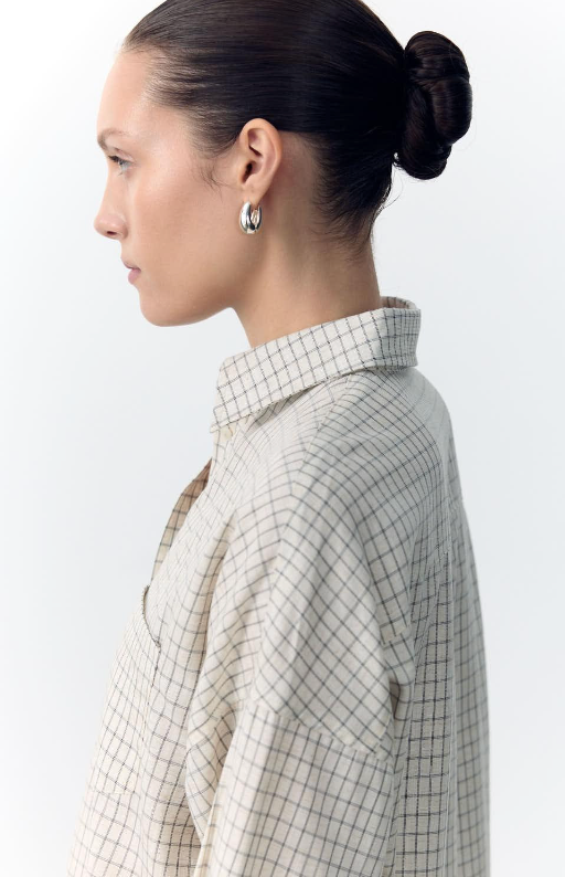 Woman wearing a checkered shirt with a plain background