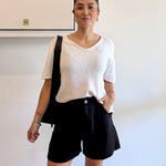 Person wearing a white shirt and black shorts in an indoor setting