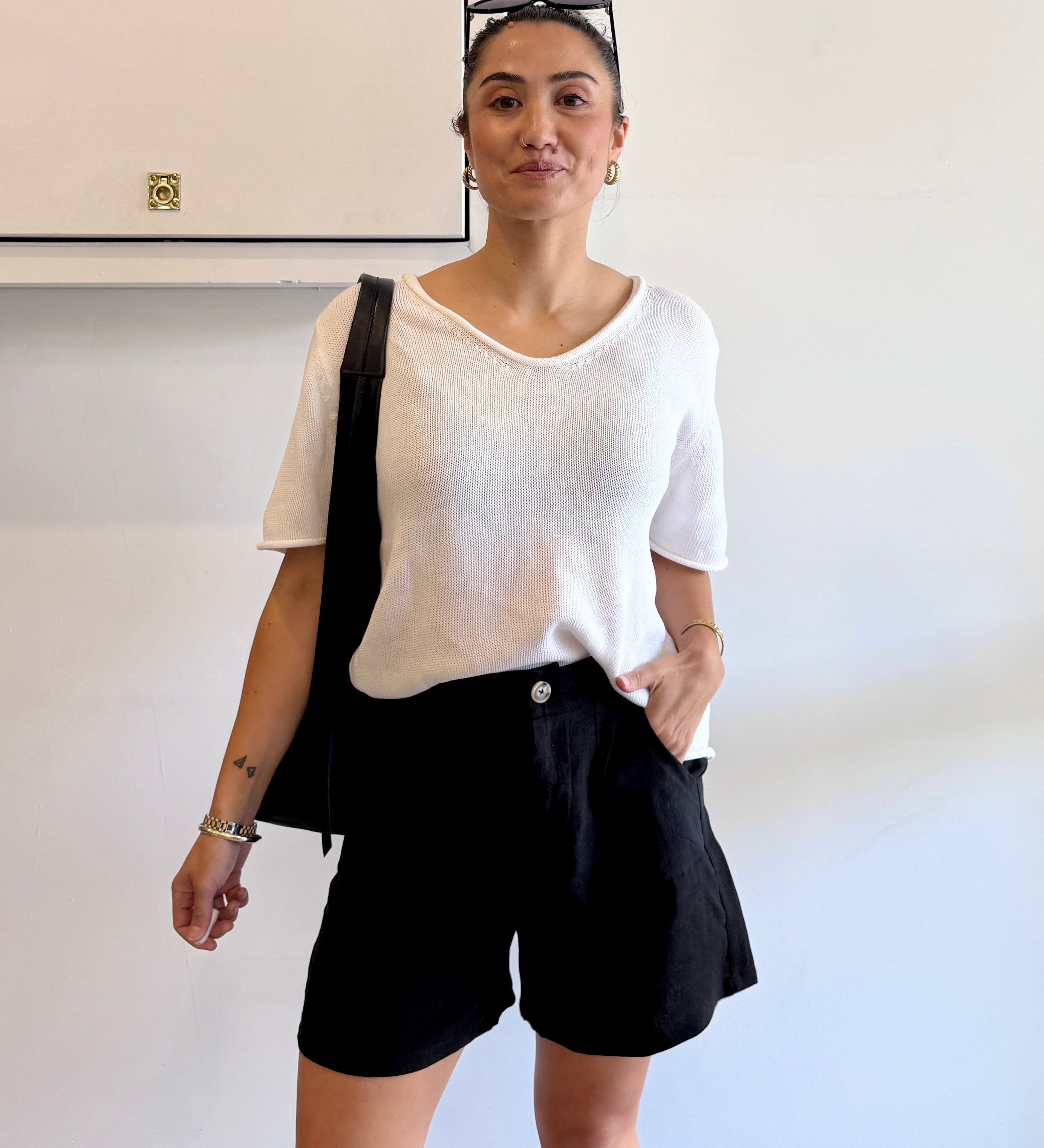 Person wearing a white shirt and black shorts in an indoor setting