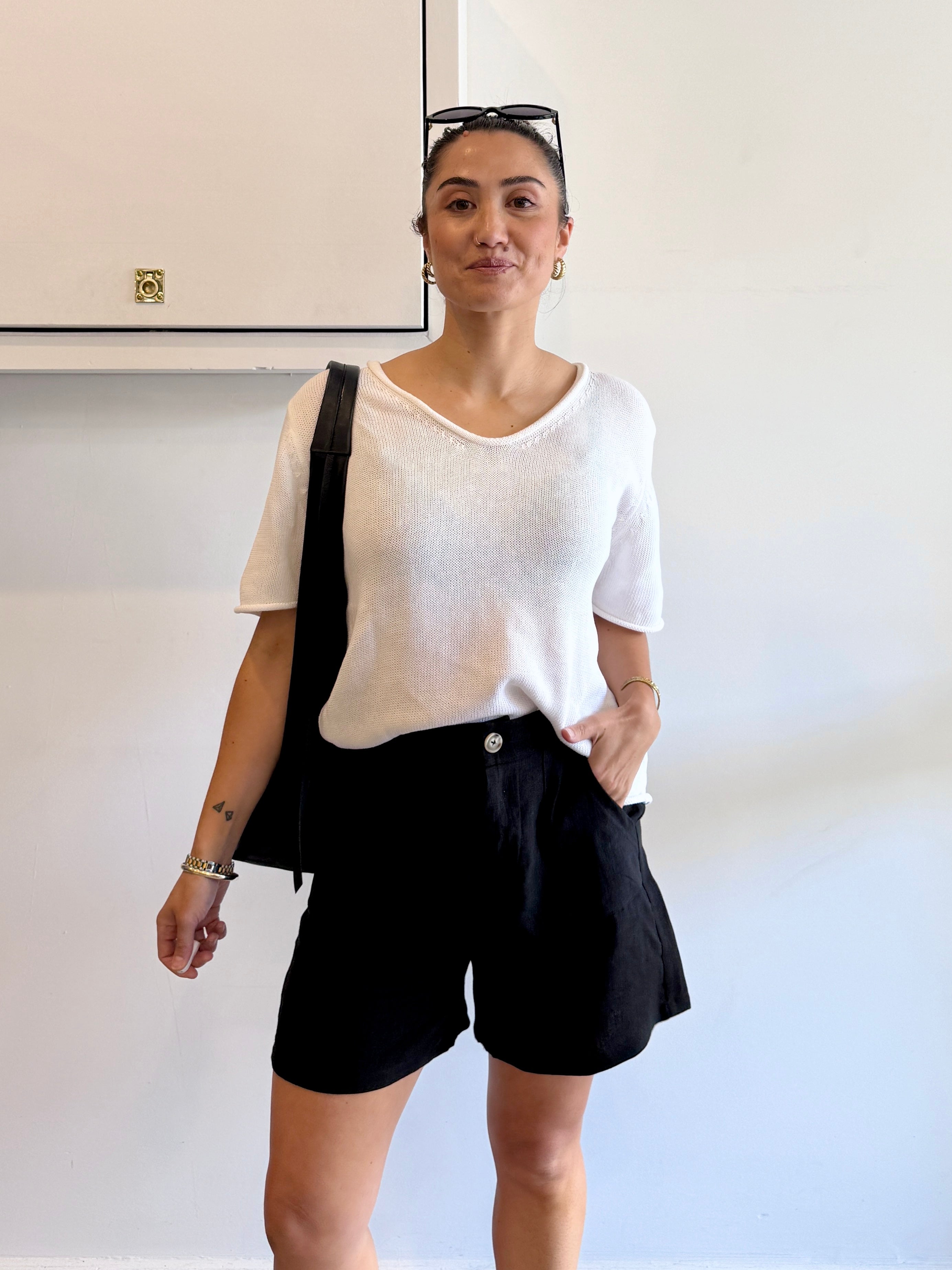 Person wearing a white shirt and black shorts in an indoor setting