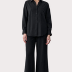 Person wearing a black outfit with text on the left side