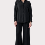 Person wearing a black outfit with text on the left side