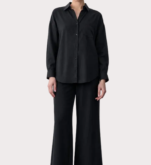 Person wearing a black outfit with text on the left side