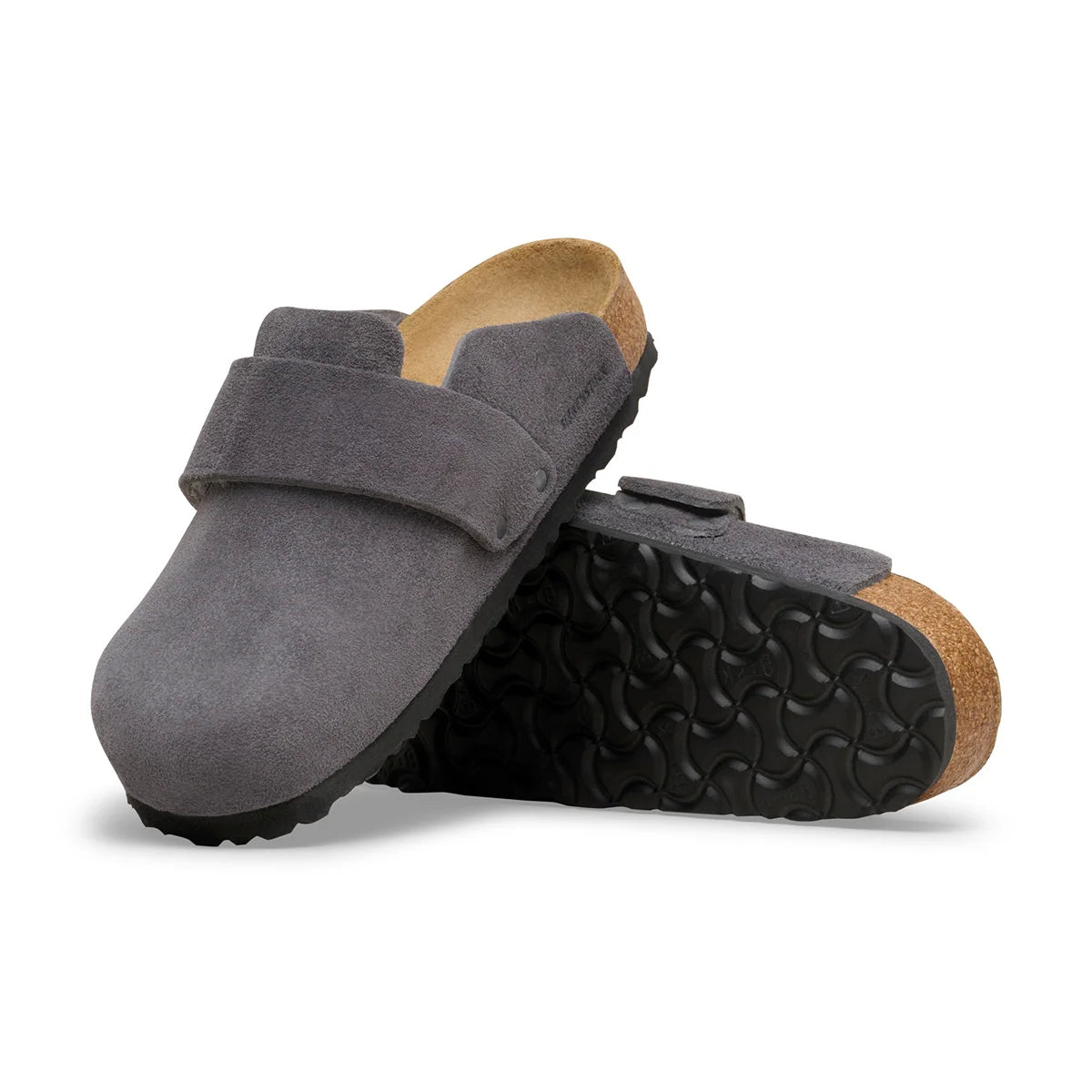 A pair of dark gray suede clogs with a black treaded sole and a natural cork back, displayed on a clean white background.