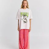 Person wearing a white oversized t-shirt with graphic design and red striped pants on a white background