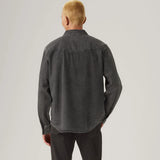 Person wearing a dark gray shirt and pants on a light gray background