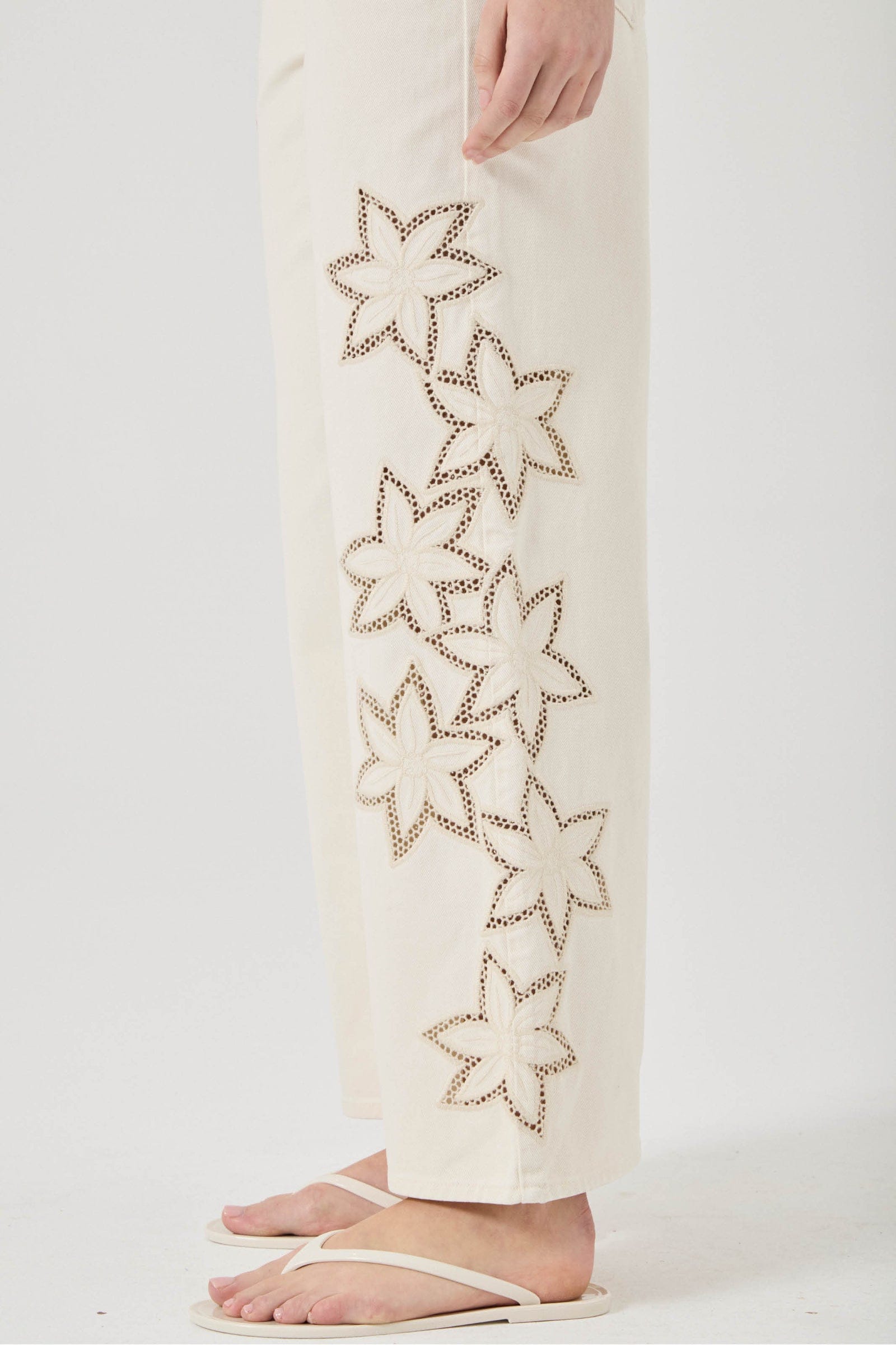 White pants with star-shaped cutouts on a white background