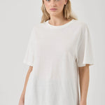 Woman wearing a white t-shirt against a plain background