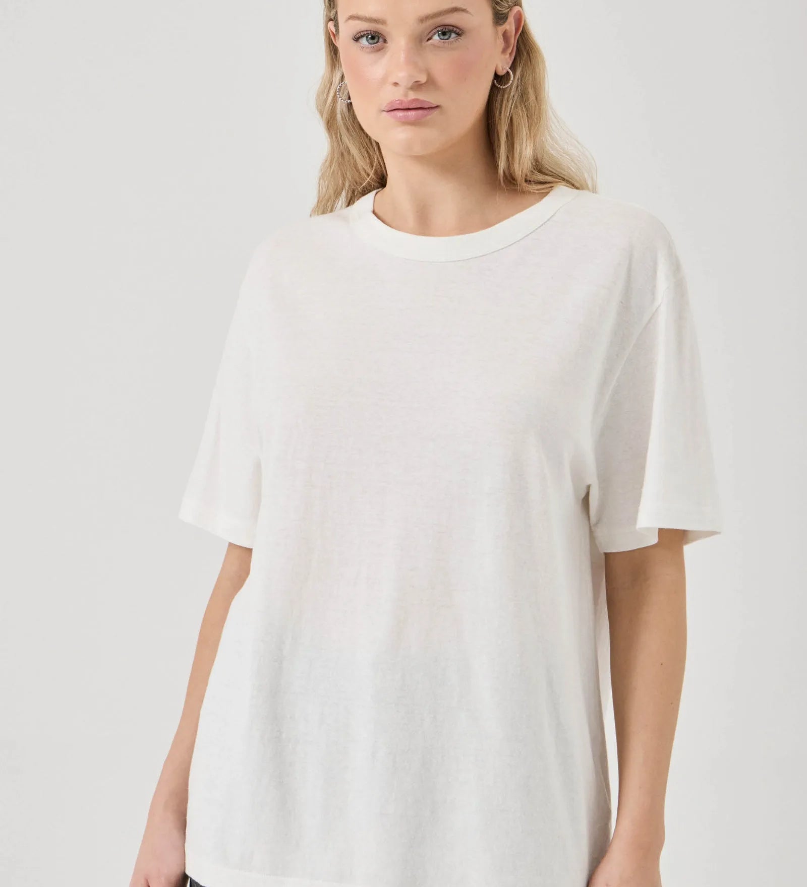 Woman wearing a white t-shirt against a plain background