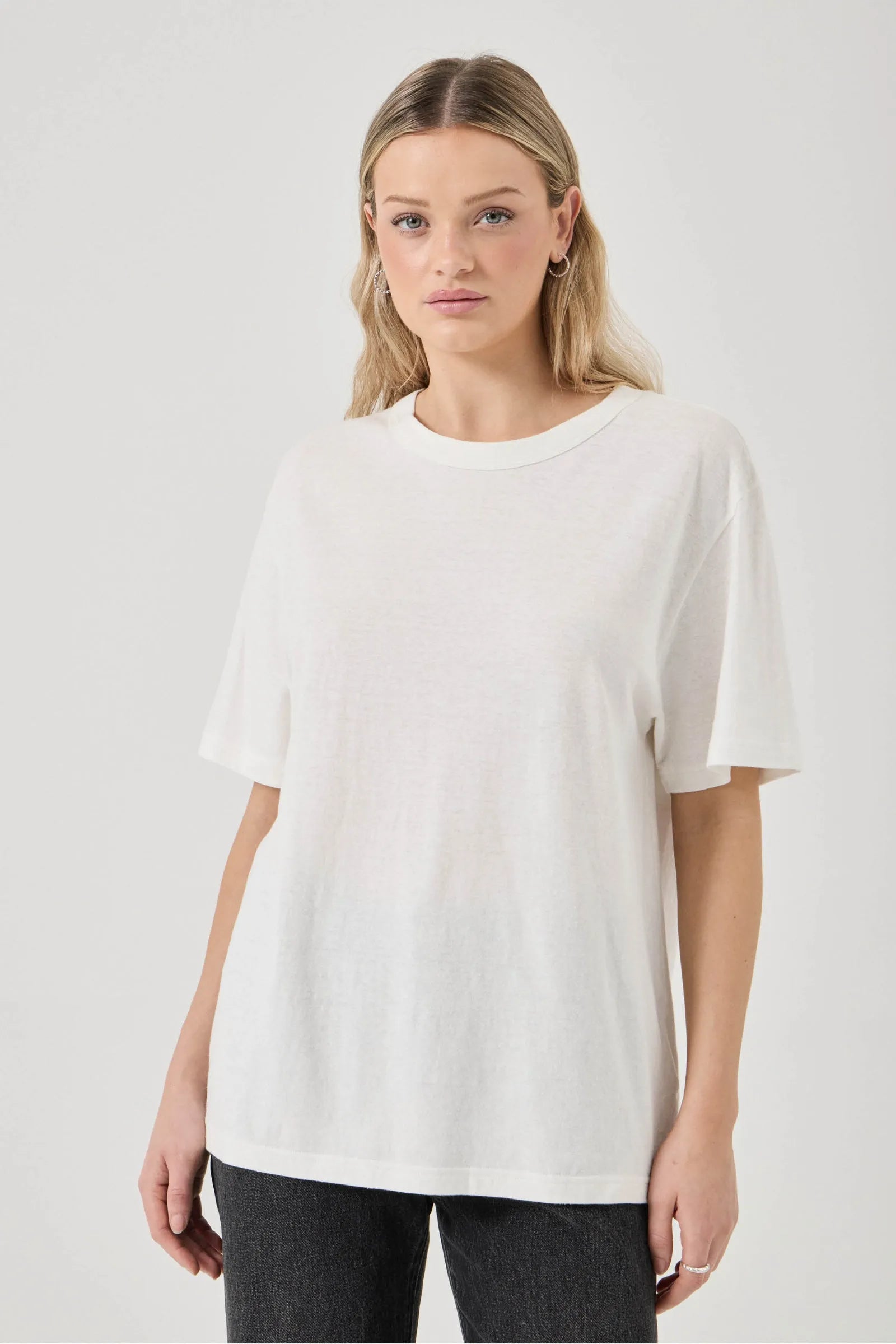 Woman wearing a white t-shirt against a plain background