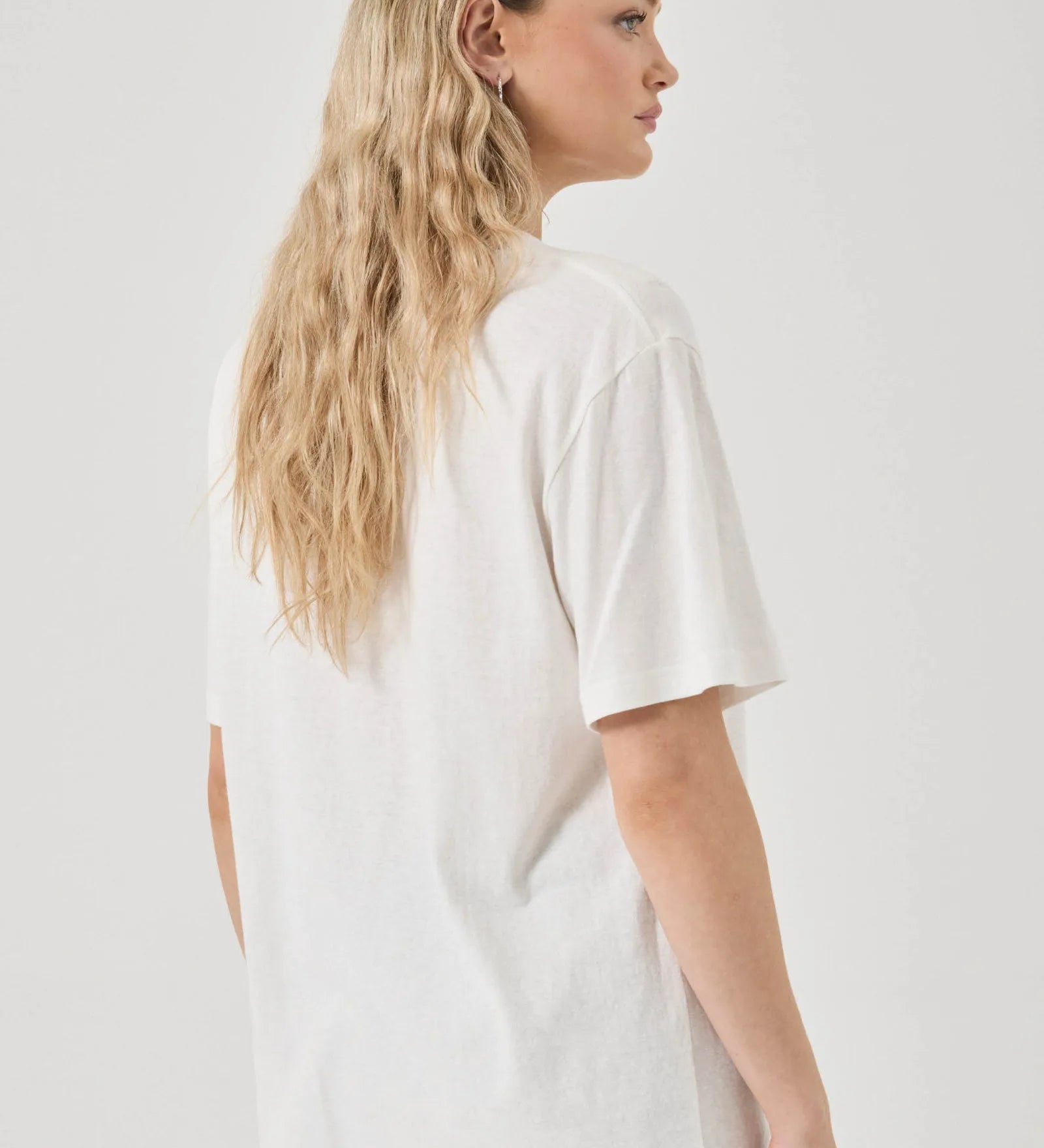 Person wearing a white t-shirt on a plain background