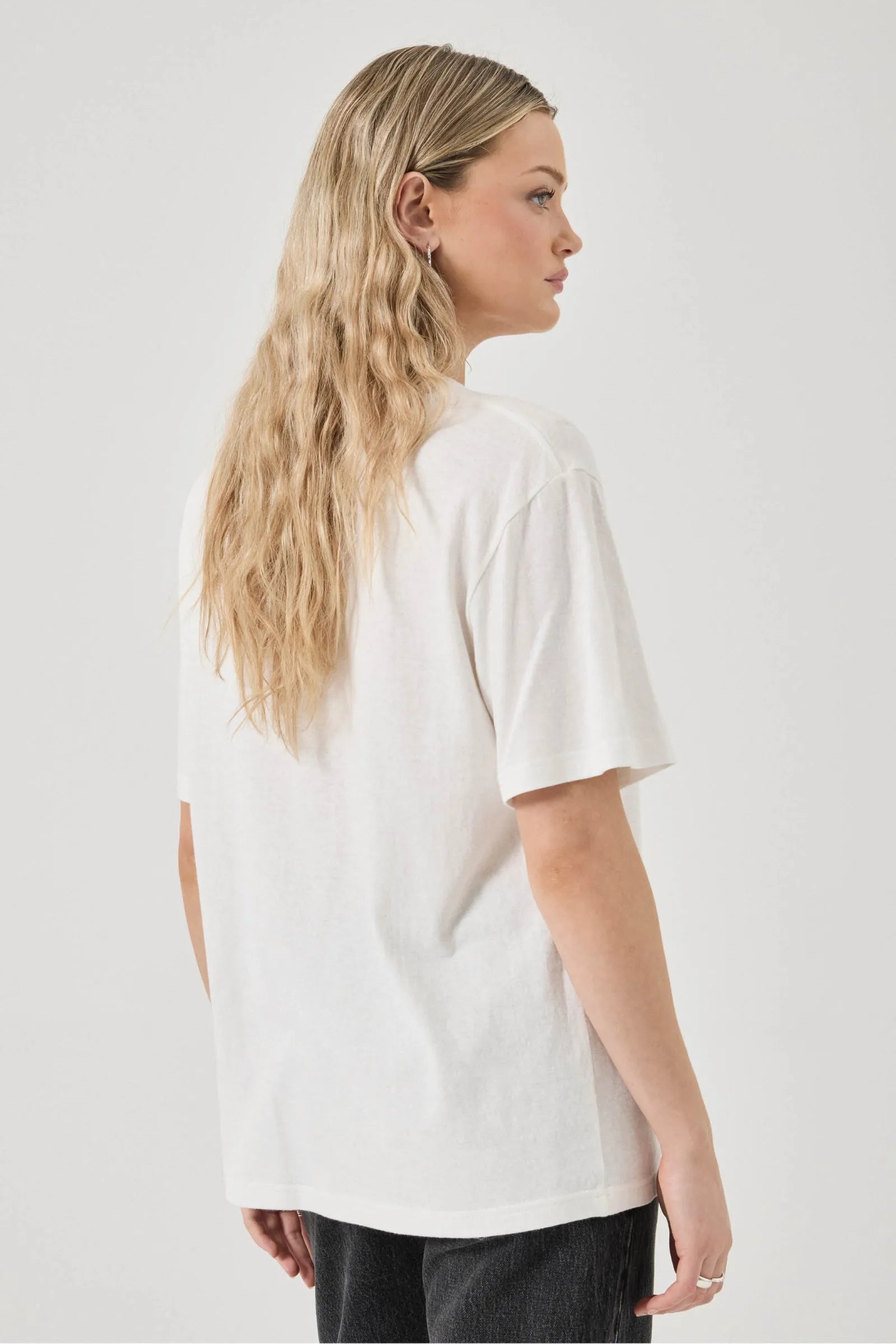 Person wearing a white t-shirt on a plain background